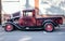 Burgundy shiny vintage retro truck with open hood at a street seasonal exhibition