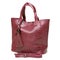 Burgundy women`s bag made of reptile skin, with handles and a strap, on a white background