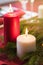 Buring red and white Christmas candles with fir-tree branch