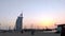 Burj Al Arab during a beautiful golden sunset shot from the Jumeirah beach with lots of seagulls | luxury seven stars hotel