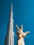 Burj Khalifa view with three fingers statue in Burj Park, Downtown Dubai, United Arab Emirates