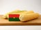 Burkina Faso flag on a wooden panel with corn isolated on a whit