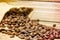 Burlap bag of coffee beans spilled onto a wood table.