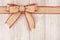 Burlap Christmas bow and ribbon top border on old white wood