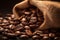 Burlap sack of coffee beans against dark wood background with whole coffee beans spilling out over wood panel