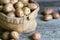 Burlap sack full of potato tubers standing on a wooden boards