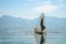 Burmese fisherman on bamboo boat catching fish in traditional way with handmade net. Inle lake, Myanmar Burma