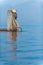 Burmese fisherman dressed in traditional style standing at the back of the boat Preparing fishing equipment