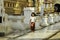 A Burmese girl is walking on a sidewalk decorated with Burmese sculpture in a temple.