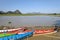 Burmese rural landscape. Colorful wooden boats at a lake. Limestone karst mountains and hills at the background. Myanmar, Burma,
