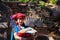 Burmese woman with thanaka face painting and basket selling blankets. Blurred stones of temple ruin background