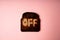 Burn off concept. one slice of dark burnt charred white bread with word Off on it on pink background.