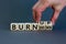 Burn up, not burn down. Male hand flips a wooden cube and changes words `burn down` to `burn up`. Beautiful grey background, c