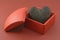 Burned black charcoal heart in box