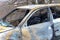 Burned car after an accident on the asphalt road. Close-up, fragment. Arson of a car, criminal showdowns