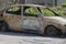 Burned car parked on the street side view - Close up photo of a burned out car
