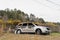 A burned minivan from a fire behind a wire fence