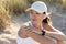 Burnette woman in baseball cap listening