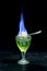 Burning absinthe in glass with lump of sugar on spoon