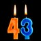 Burning birthday candles in the form of 43 forty three for cake isolated on black background.