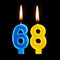 Burning birthday candles in the form of 68 sixty eight for cake isolated on black background.