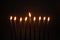 Burning blue candles on a Jewish menorah at Hanukkah on a dark brown background