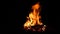 burning bonfire on a black background with bright erupting sparks.