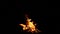 burning bonfire on a black background with bright erupting sparks.