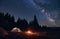 Burning bonfire in tent city under bright starry sky with Milky way against the backdrop of silhouettes pine forest