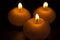 Burning bright golden candles on black background. Festive or mourning candles