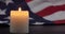 A burning candle on the background of the flag of the United States.