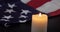 A burning candle on the background of the flag of the United States.