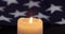 A burning candle on the background of the flag of the United States.