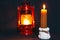 A burning candle on the background of a kerosene lamp. Festive arrival. Beautiful handmade candles. Cozy atmosphere in the house