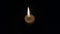 Burning candle on a black background. The candle flame flickers slowly.