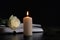 Burning candle, book and white rose on table in darkness, space for text