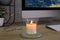 Burning candle, glasses and computer on wooden table indoors