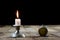 Burning candle and old watch on a wooden table. Flowing time and