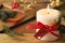 Burning candle with pinecone scent on wooden table, closeup. Space for text