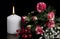 Burning candle  red and white flowers  berries  greeting card for lovers on black background. Love and passion