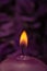 Burning candle with soothing purple background