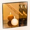 Burning candle on spherical mirror shelf