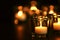 Burning candle on table against blurred background. Funeral symbol