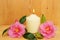 Burning candle and two camellia flowers