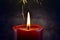 A burning candle and yellow sparks on a dark background. Christmas and New Year illustration