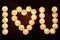 Burning candles arranged in the shape of heart. Inscription I LOVE YOU