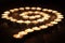 Burning candles arranged in spiral, circle at night on wooden table. Meditation, spiritual concept.