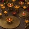 Burning candles in brass candlesticks with flowers on wooden background by ai generated