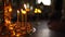 Burning candles in a candlestick on background of blurred dark room