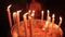 Burning candles close-up on a church candlestick. A girl puts a candle to us in the background